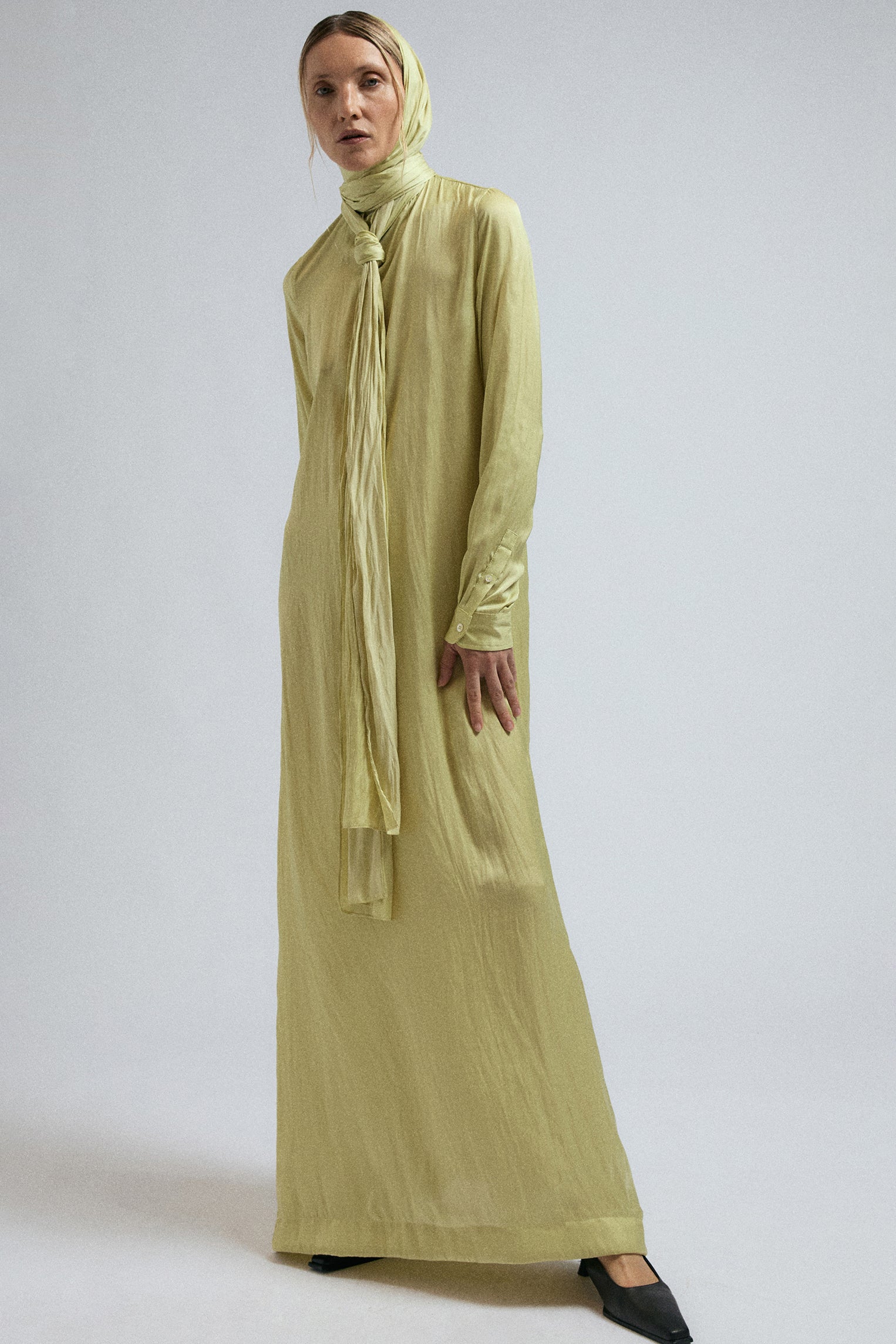 Woman wears JordanLuca's FW24 Bow Dress in Canary Yellow, the shawl wrapped around her head.