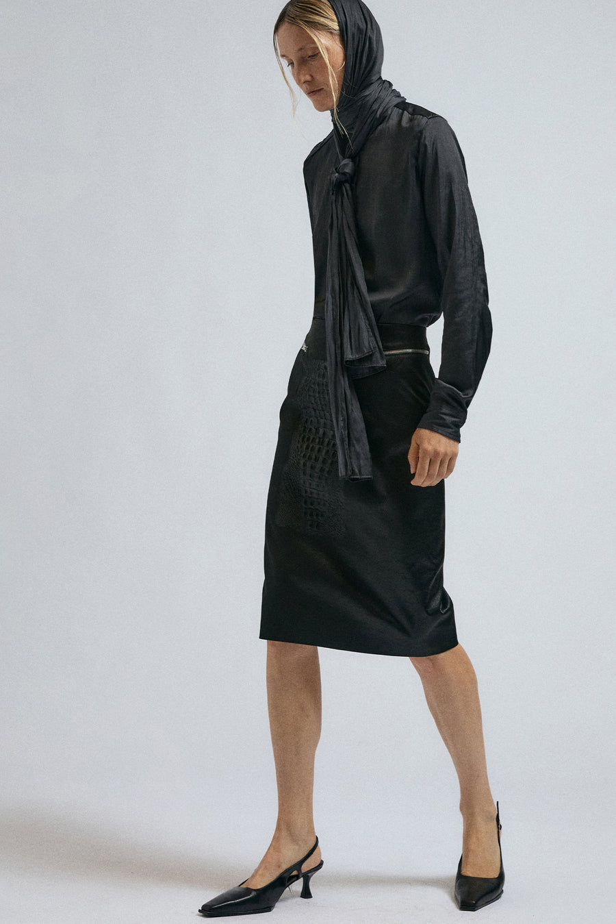 Woman wears the JordanLuca FW24 black bumpster skirt, paired with the satin bow shirt.