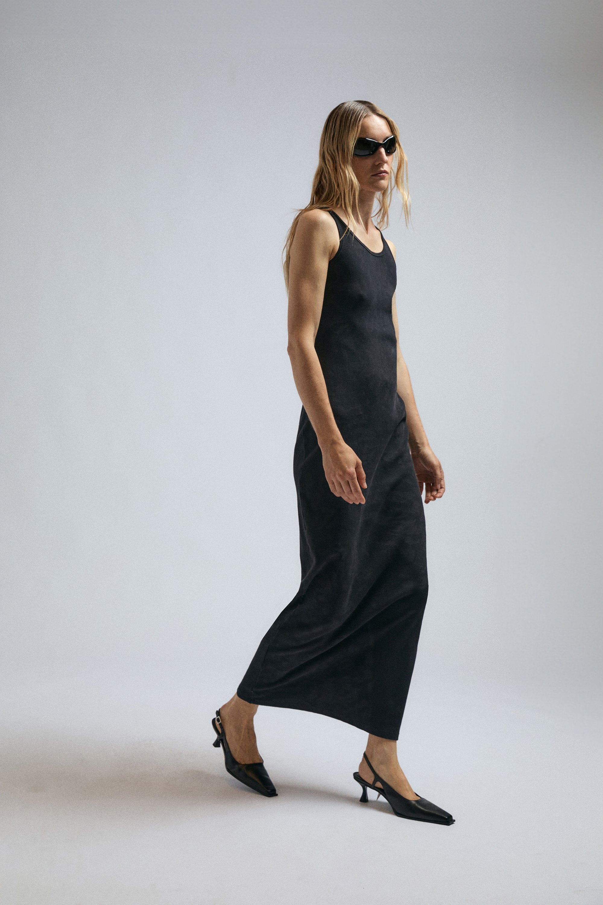 Woman wearing black jersey dress by JordanLuca with XP1 sunglasses.