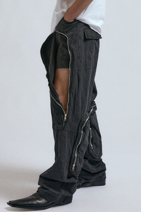 Man wearing black JordanLuca Voltage Cargo trousers, with the zip partially open.